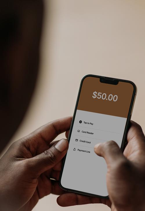 Person holding a phone showing a $50 payment screen with options for payment methods.